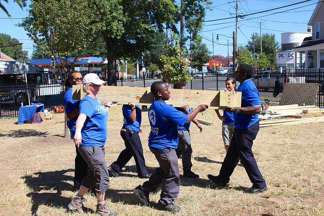 Volunteers carry wood at Democracy Prep in Washington, DC, September 11, 2015. Photo credit: GREG CALLAN, DEMOCRACY PREP PUBLIC SCHOOLS