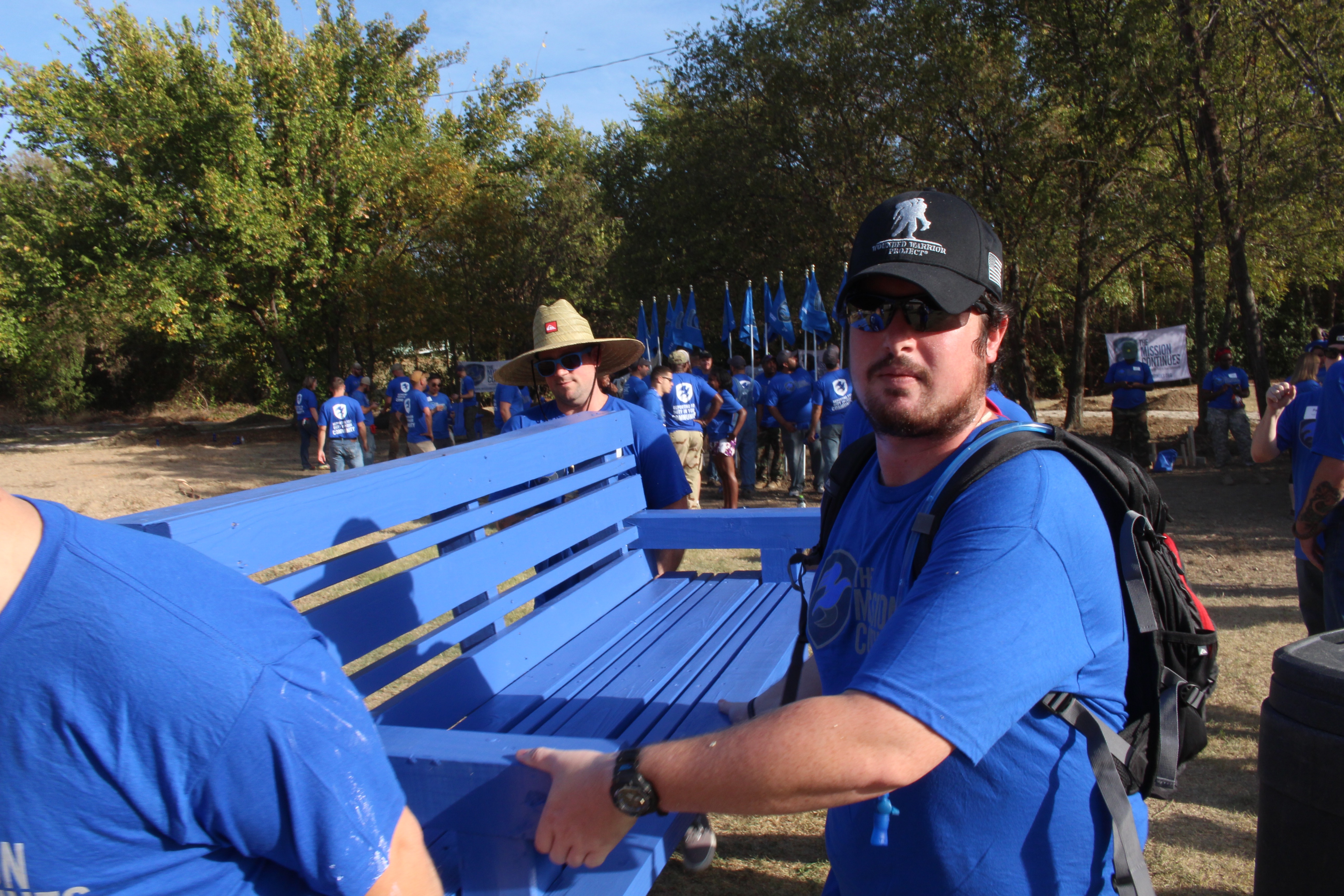A new Fellow and Wounded Warrior Project alum install a freshly painted bench.