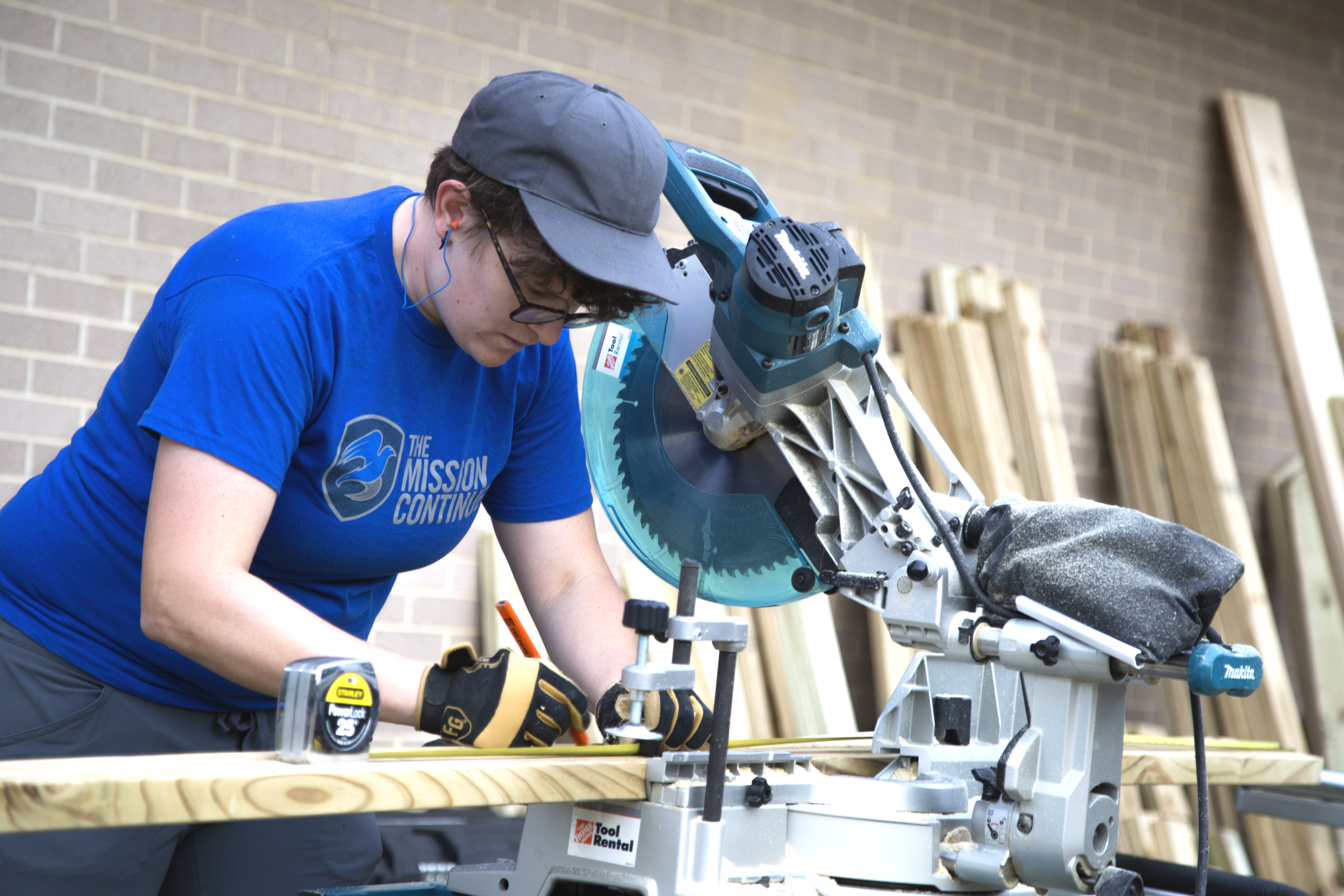 The Mission Continues staffer Jess measures wood to cut.