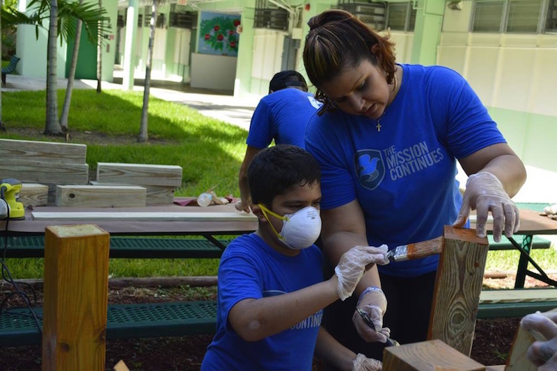 Derek Auguste's wife and son volunteering at a service project with The Mission Continues